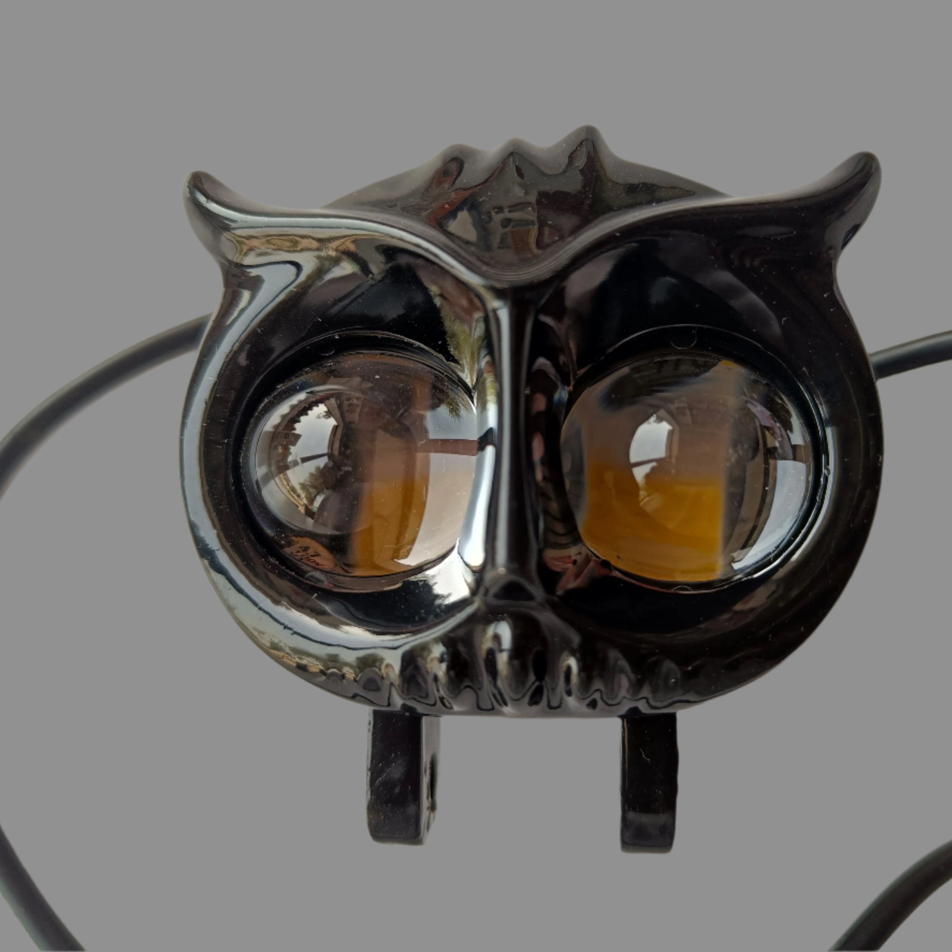 Owl-shaped light fixture with black and chrome design on a white background