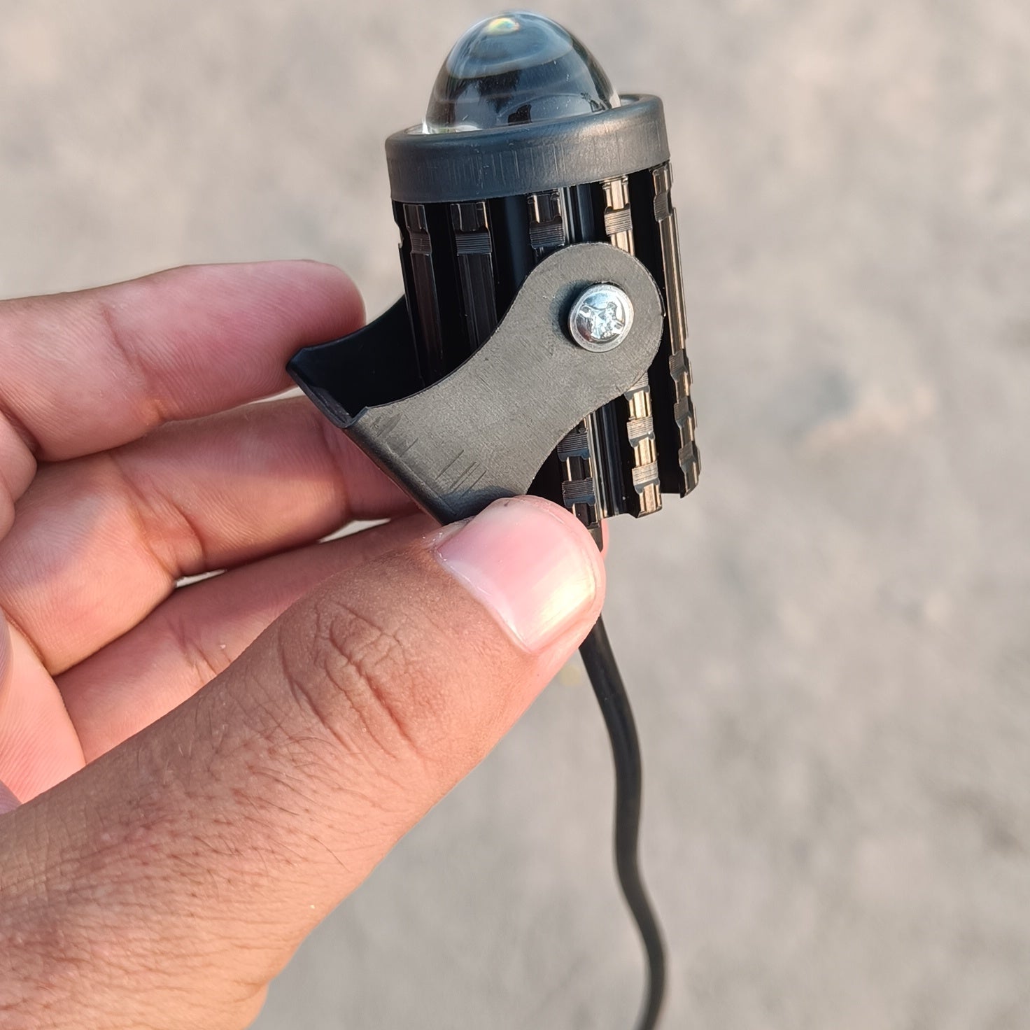 Small electronic device held in a hand against a neutral background