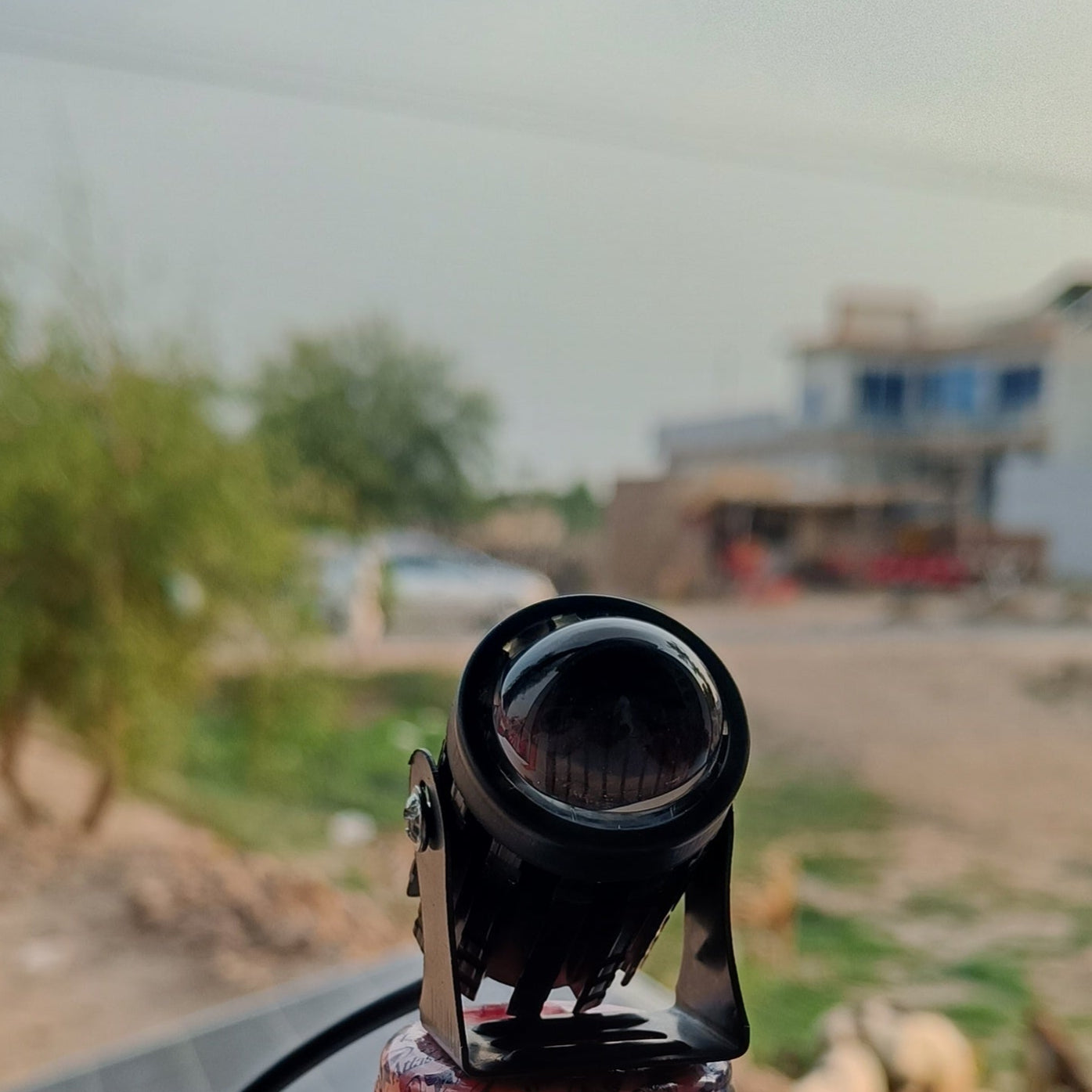 Camera attached to a bottle with a blurred outdoor background